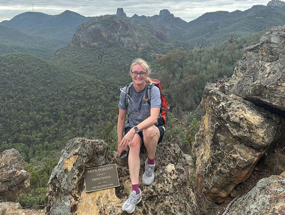 Belinda sitting on rocky outcrop in front of scenic view